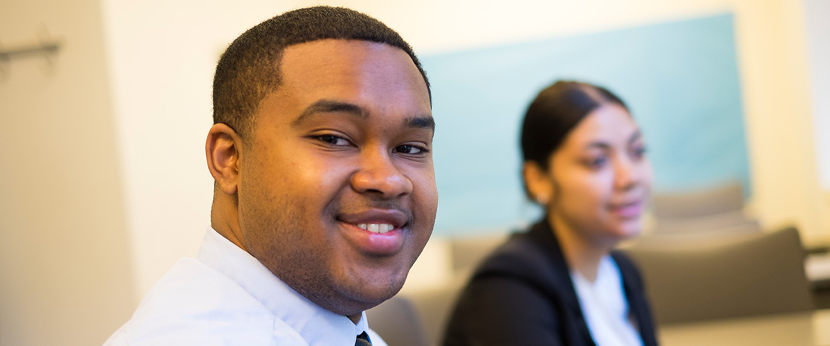 Man in classroom with woman blurred in background