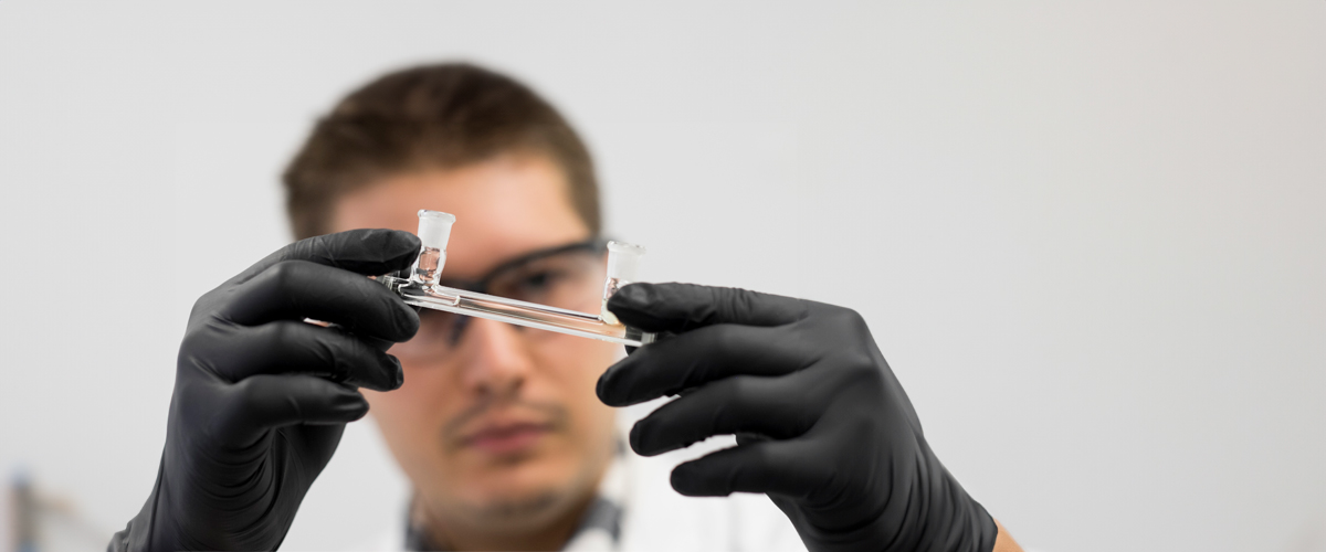 A biotechnology student holds up a piece of equipment.