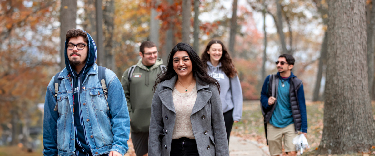 A group of students are walking around the Long Island campus in the fall.