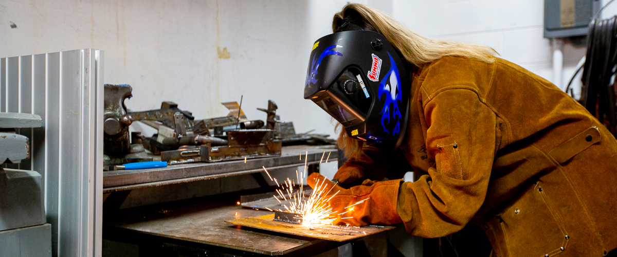 In one of New York Tech's applied learning spaces, a Mechanical Engineering, B.S. student uses a welding machine.