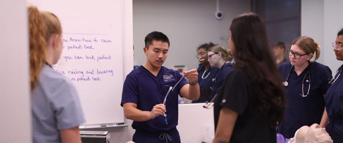 Medical student in a lab practicing intubation.