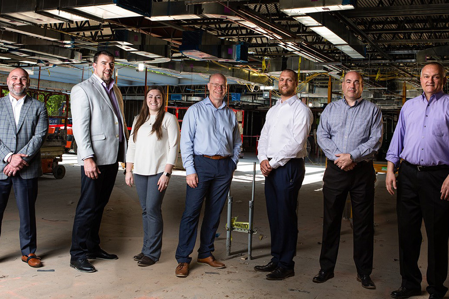 A group of 7 people who are key players in the BRIIC building construction standing in one row.