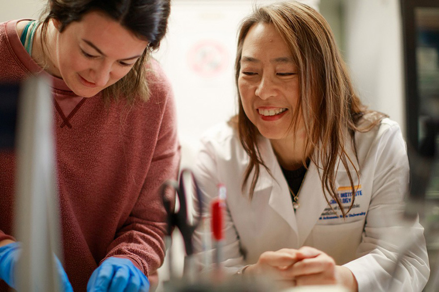 Jennifer Xie, Ph.D., mentors a student researcher in her biomedical sciences laboratory.