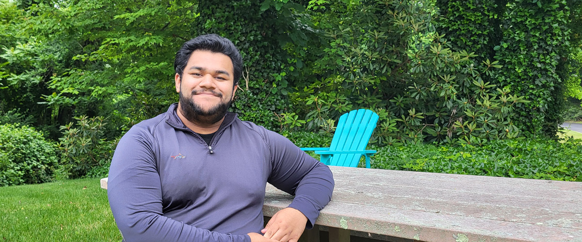 New York Student Alex Menachery sitting on a bench