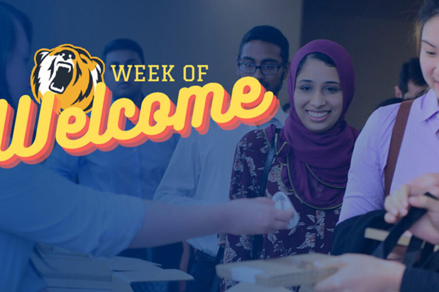 Group of students grabbing lunch packs with Week of Welcome Logo