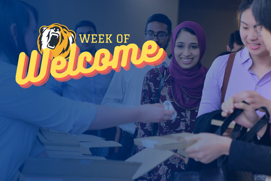 Group of students grabbing lunch packs with Week of Welcome Logo