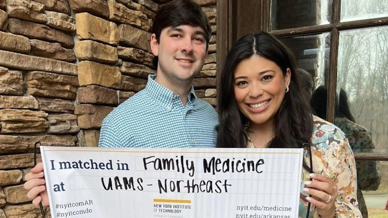 Two students holding their match sign.