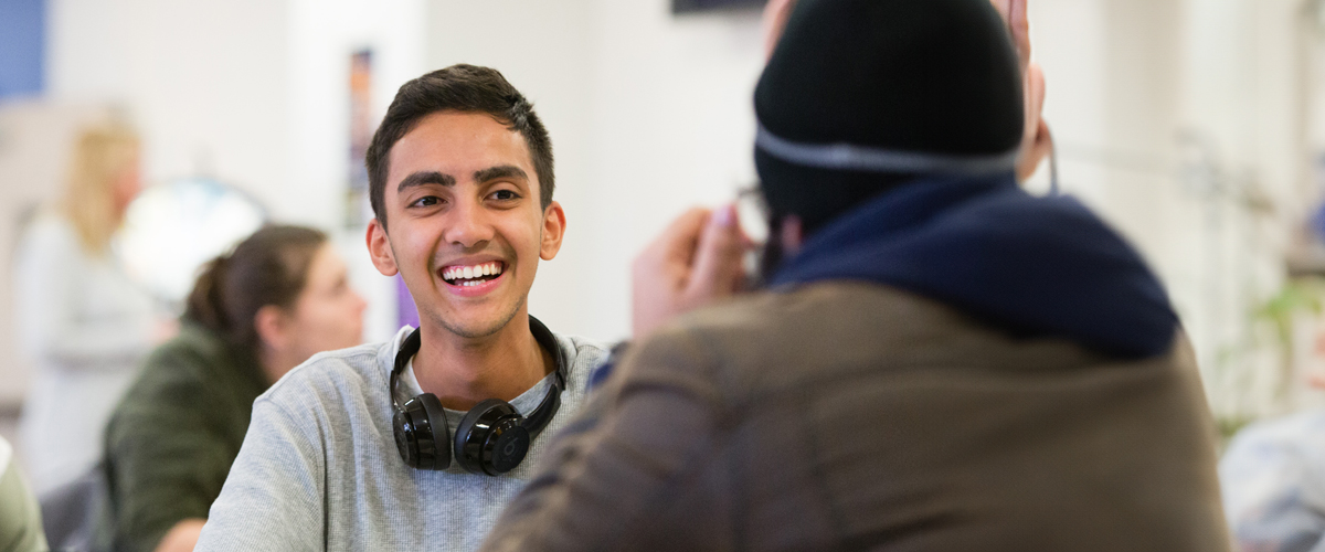 Two students have a conversation in a common area on one of New York Tech's campuses.